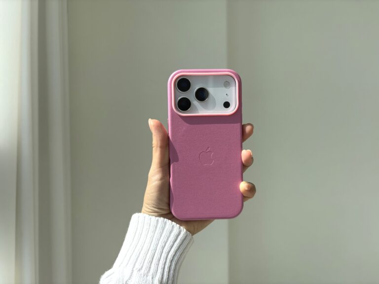 진한 핑크 색상의 가죽 케이스가 장착되어 있는 아이폰의 모습