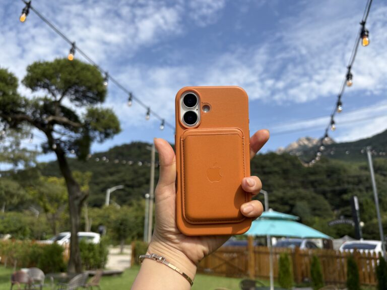 아이폰의 카메라부분을 강조해 들고 있는 장면