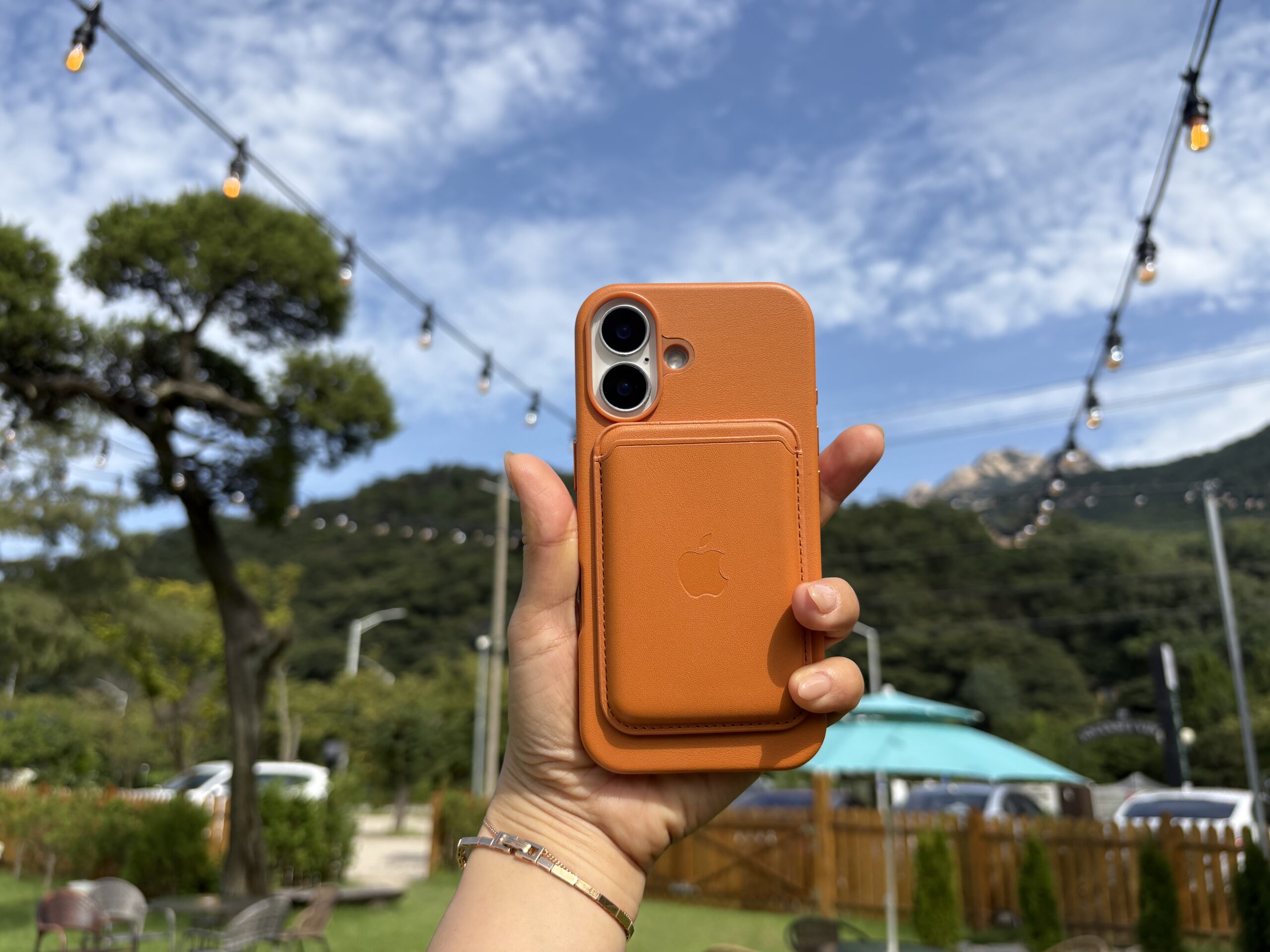 아이폰의 카메라부분을 강조해 들고 있는 장면